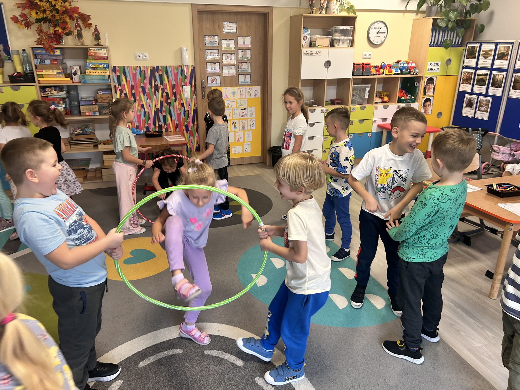 Dzieci pokonują tor przeszkód z hula-hop.