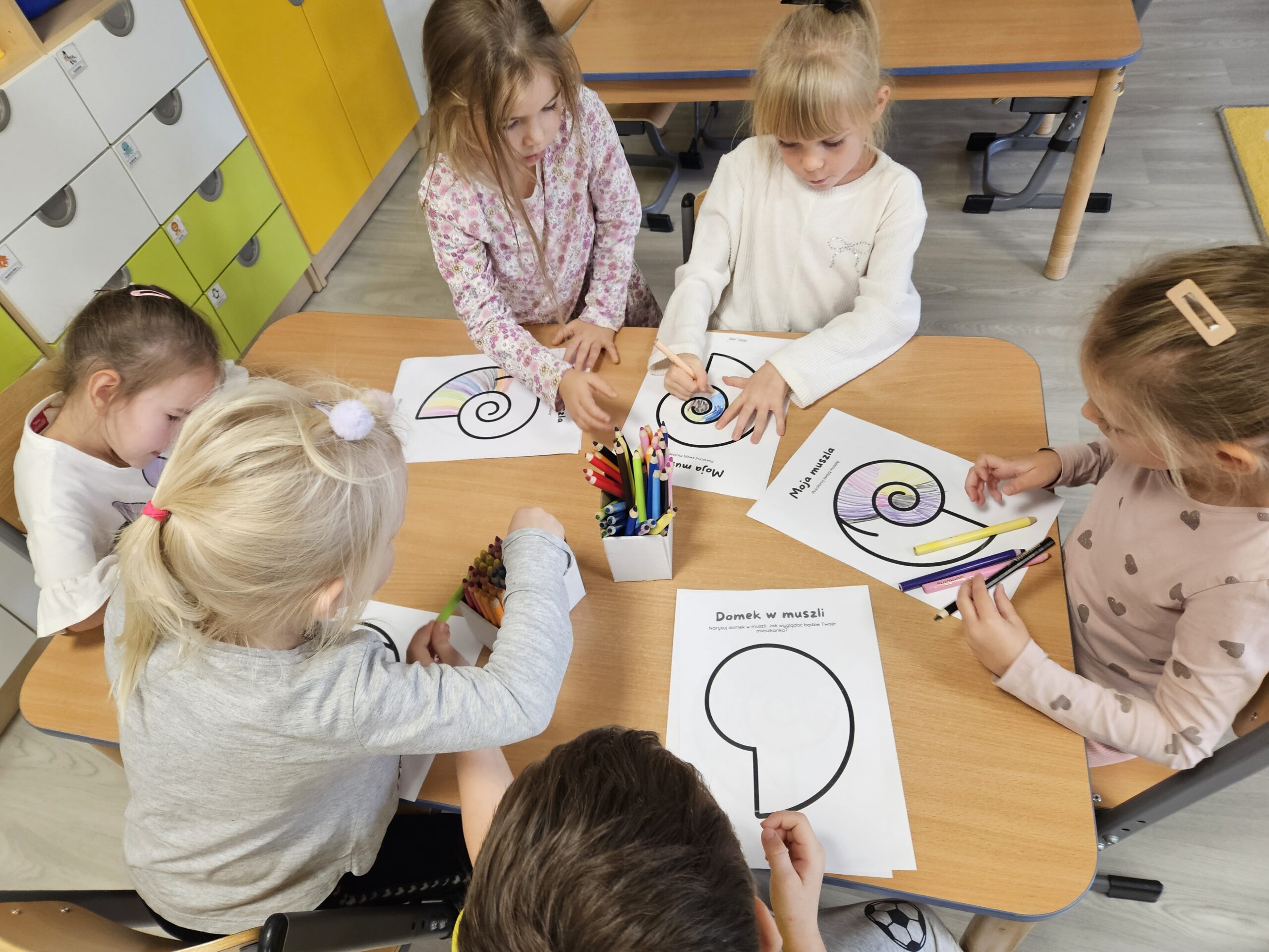Dzieci realizują kartę pracy pt Moja muszla-mój dom.