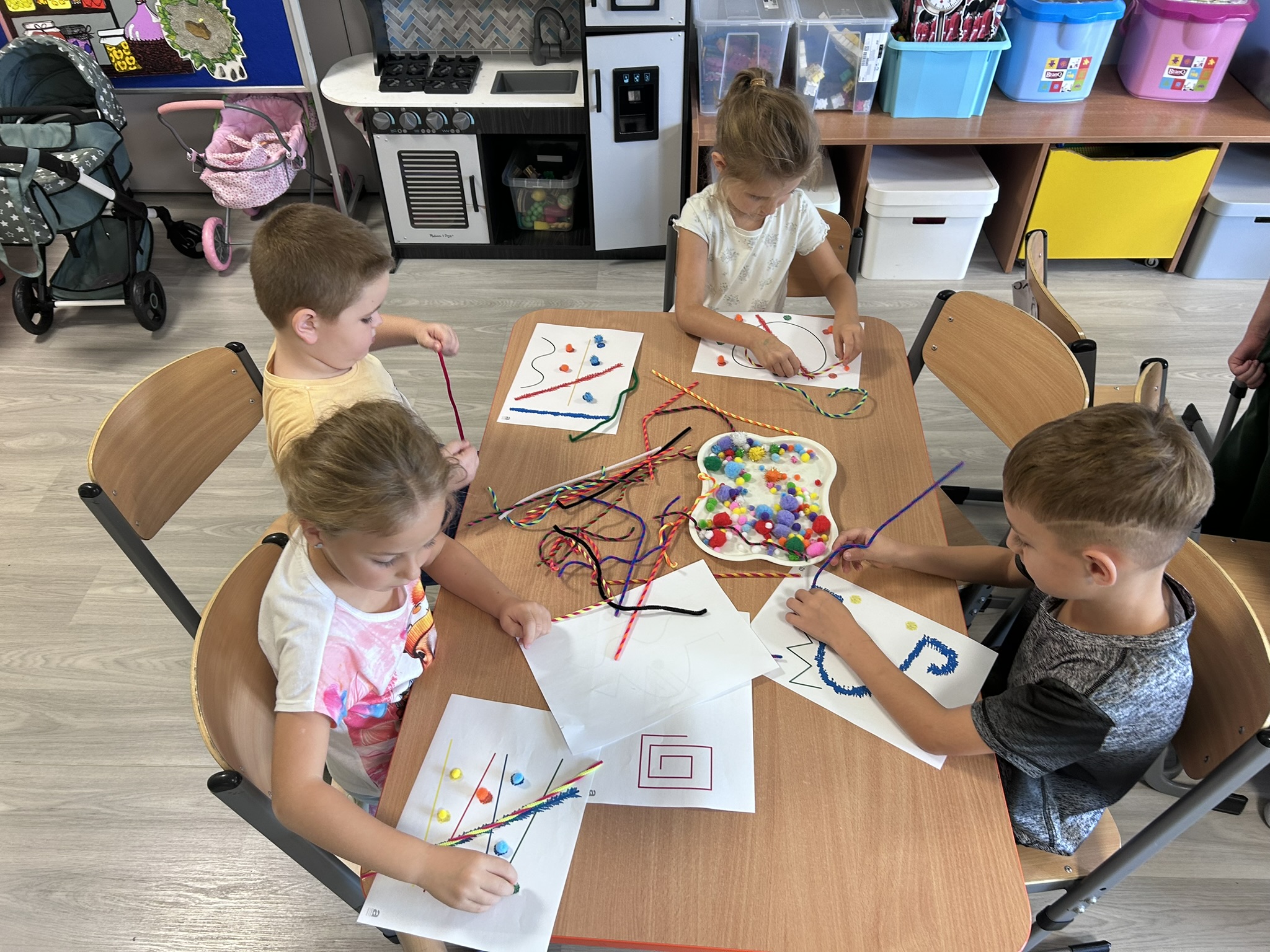 Dzieci układają wzory z drucików kreatywnych oraz pomponów.