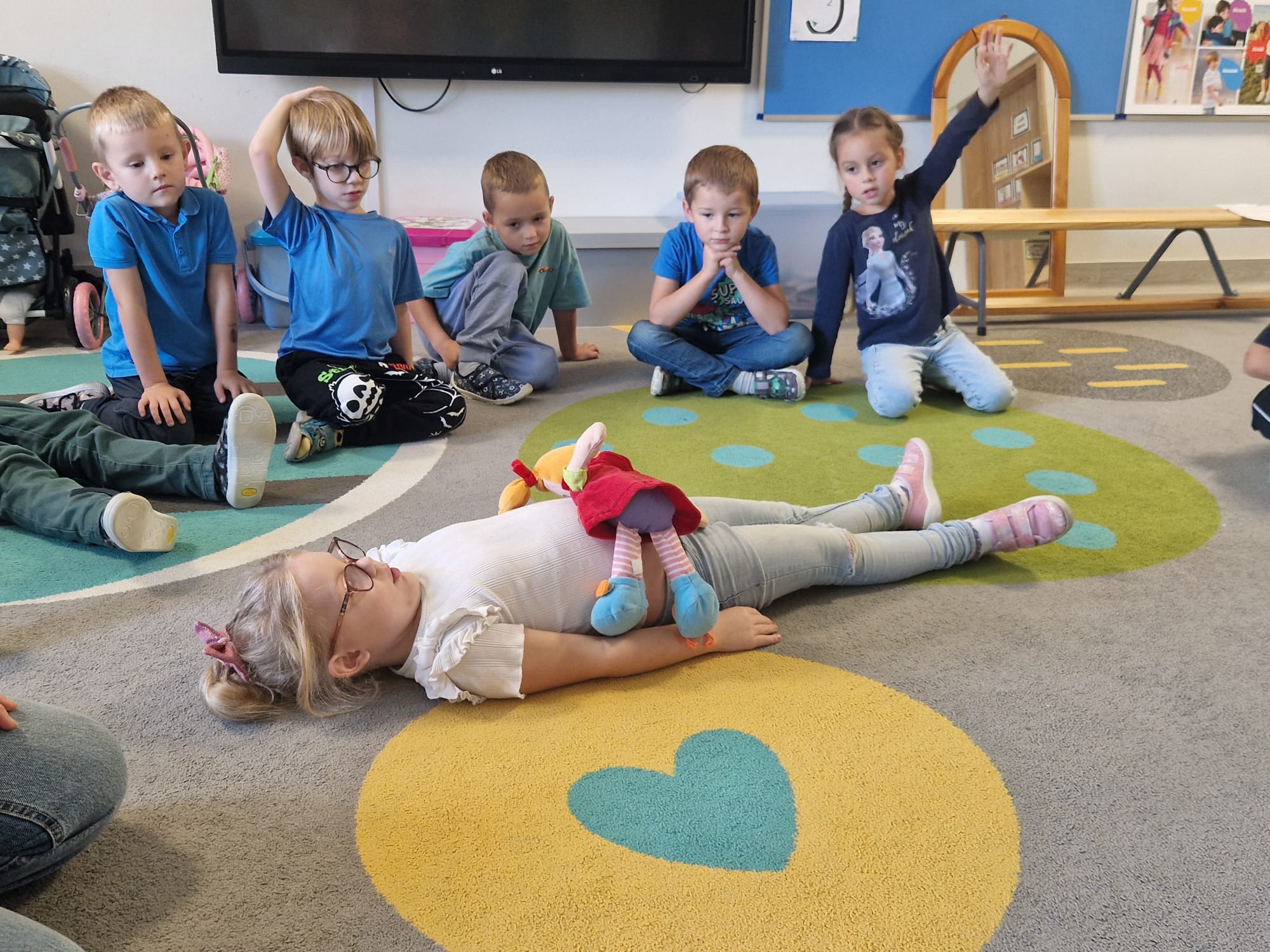 Dziewczynka ćwiczy z maskotką prawidłowy tor oddechowy.