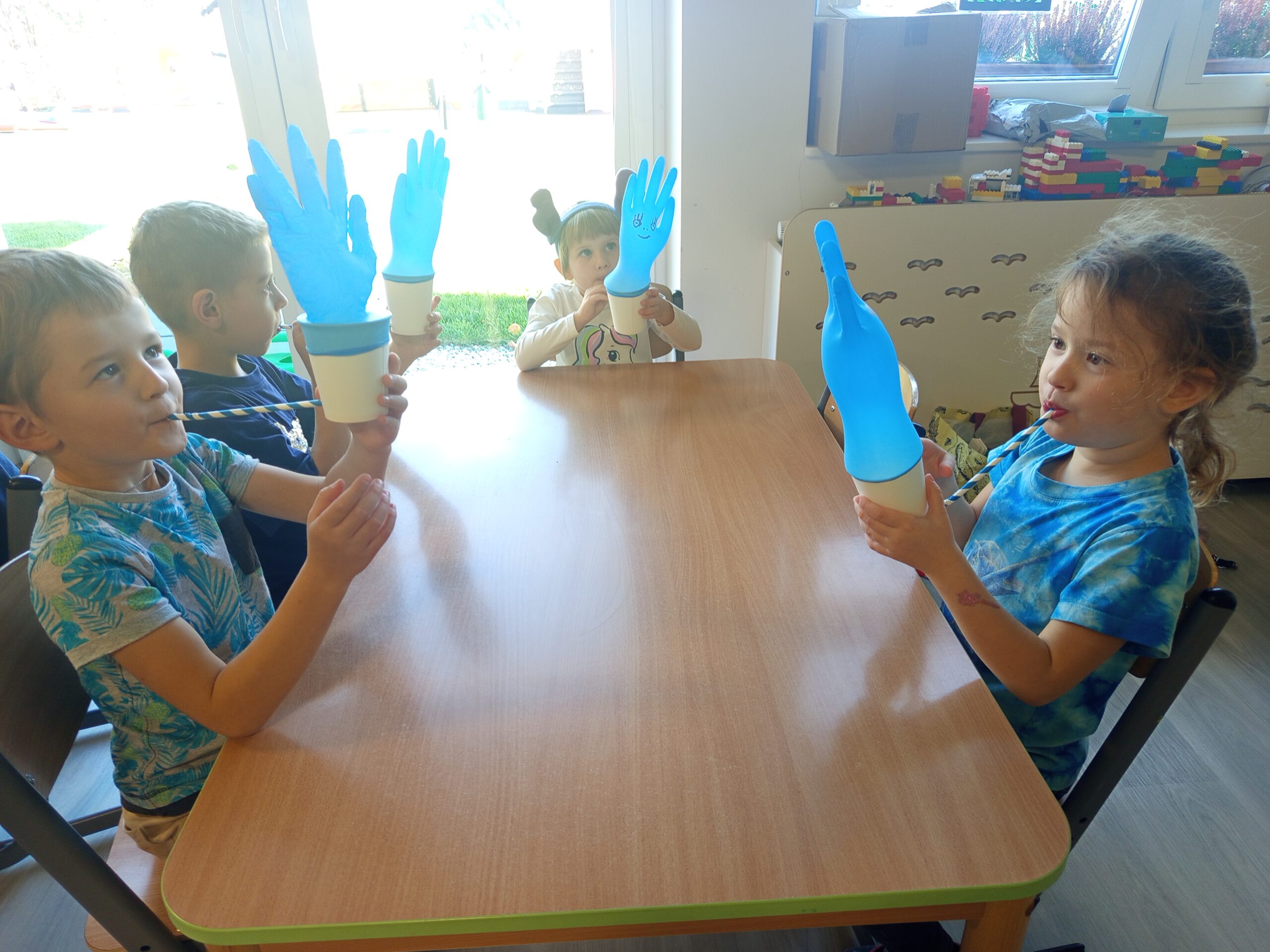 Dzieci dmuchają w samodzielnie wykonane zabawki oddechowe.