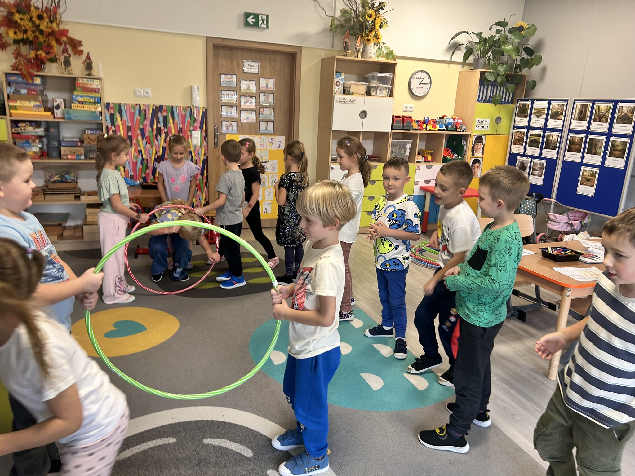 Dzieci przechodzą przez hula-hop.