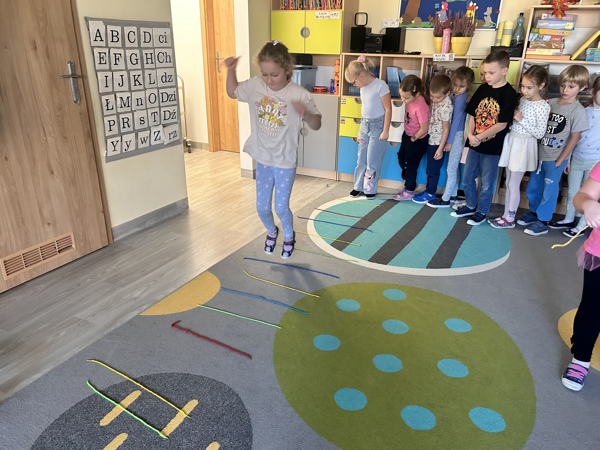 Dzieci przeskakują przez sznurki