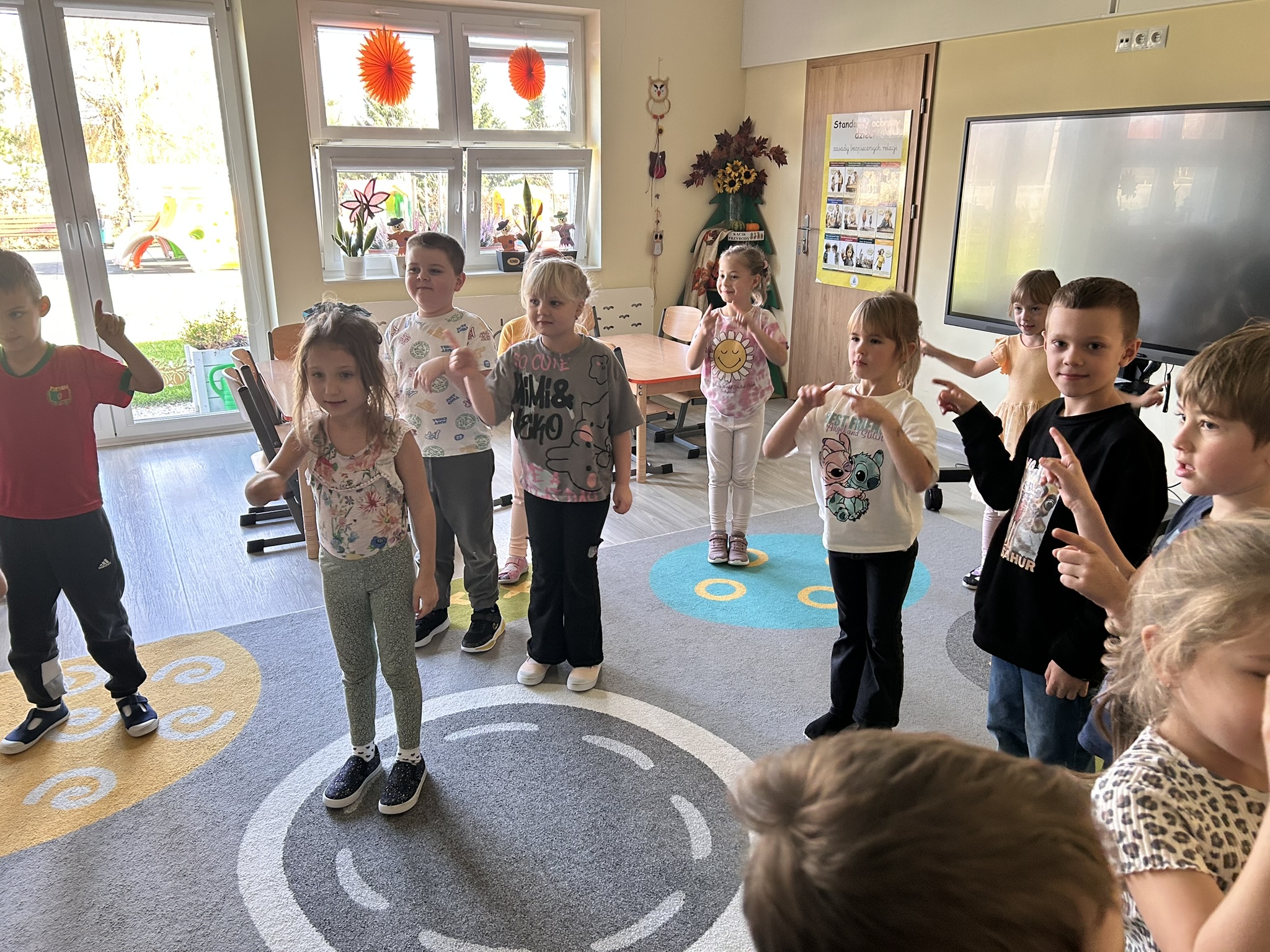 Przedszkolaki kreślą koła w powietrzu.