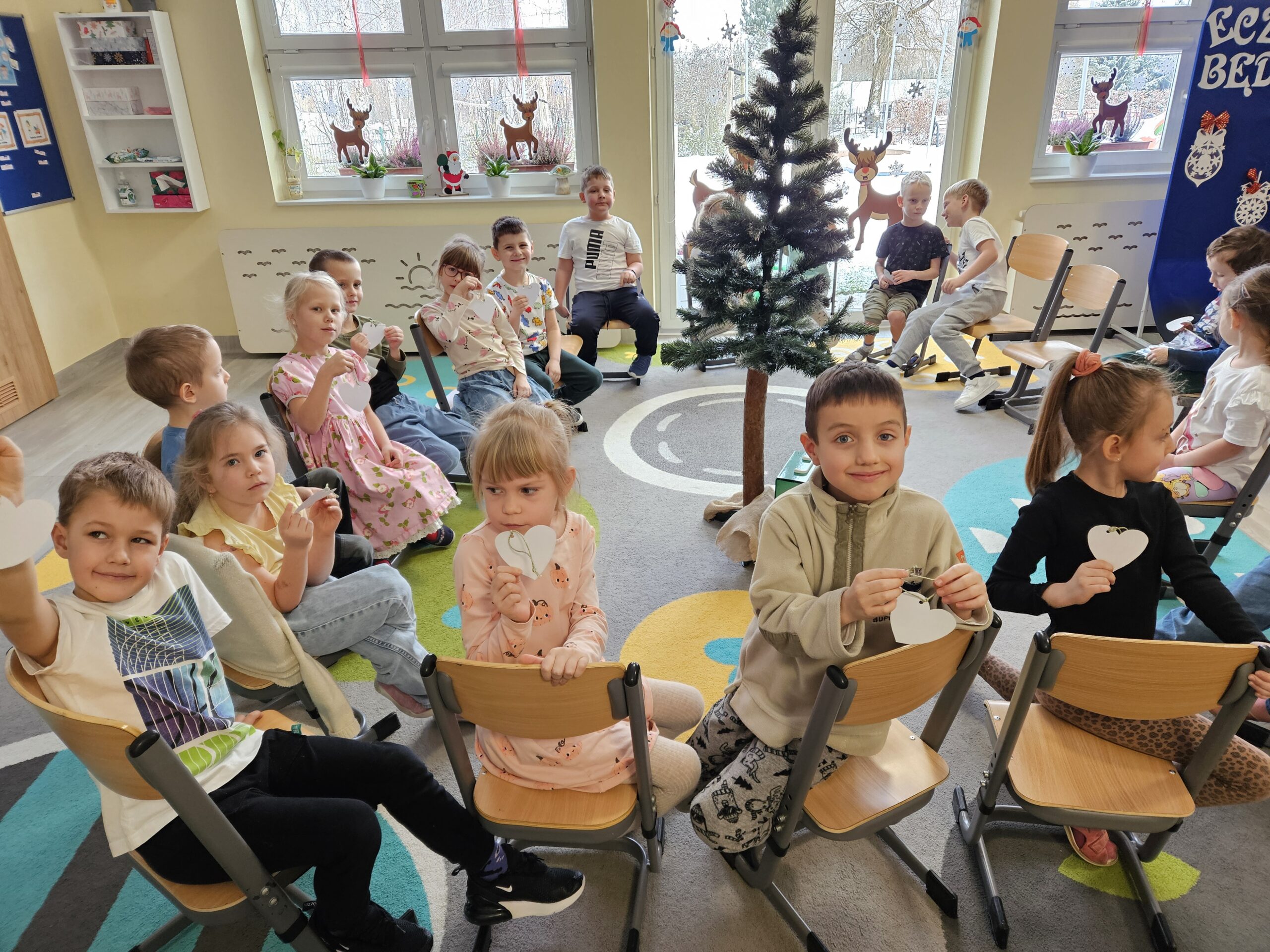 Dzieci dostają serduszka z papieru do narysowania pomysłów na dobre uczynki.