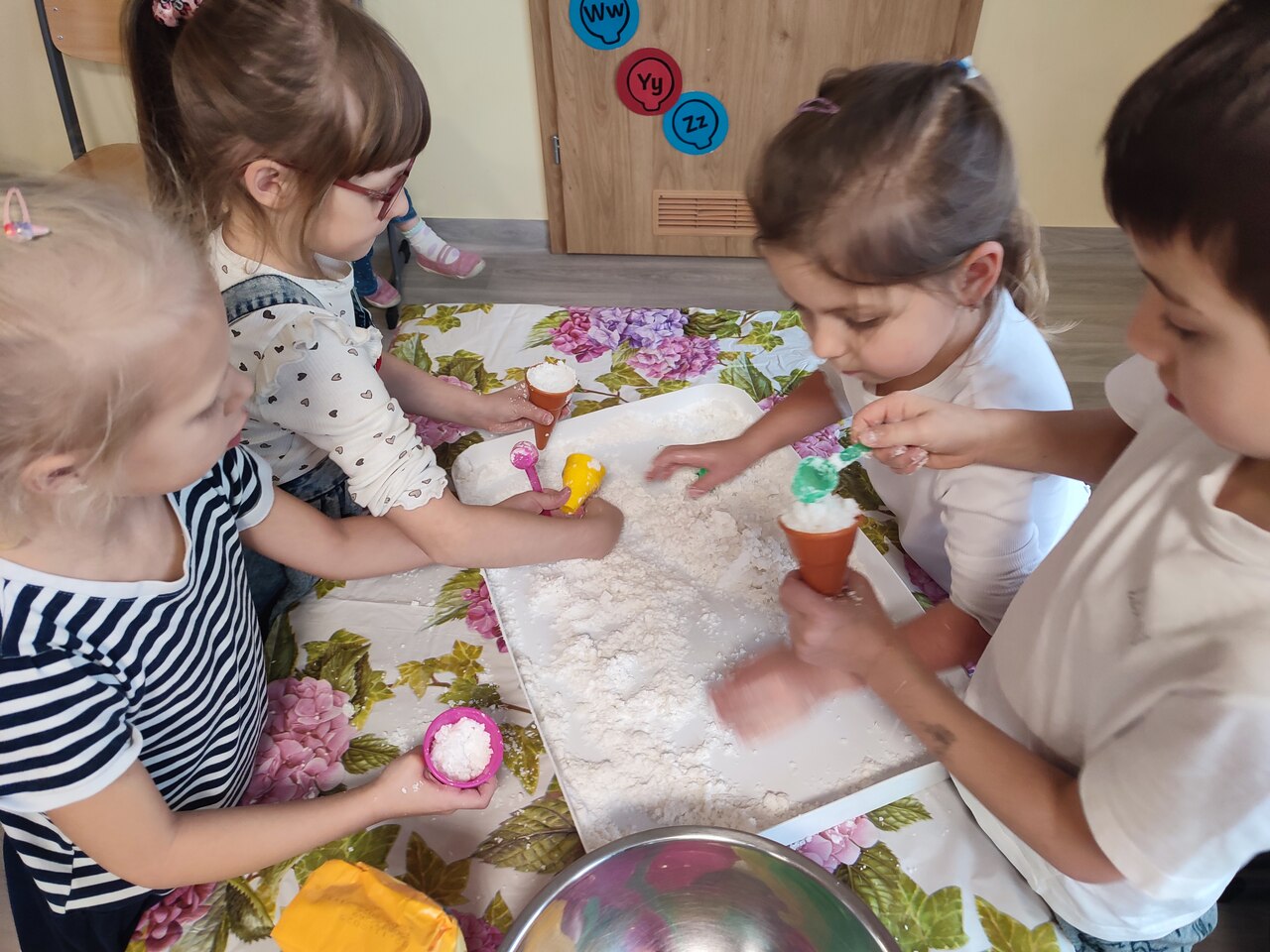 Dzieci poznają konsystencję sztucznego śniegu.