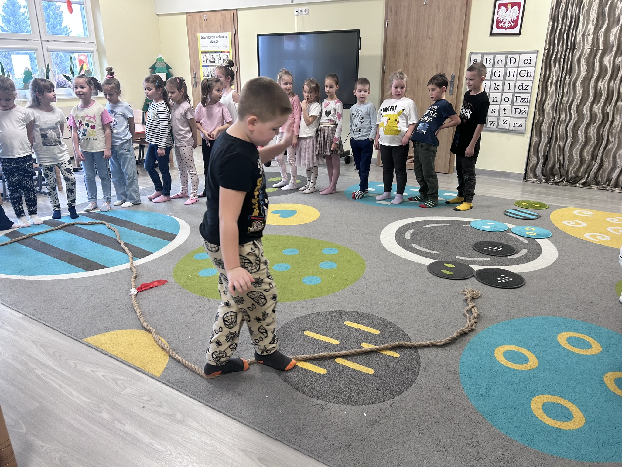 Chłopiec pokonuje tor przeszkód - chodzenie po linie.