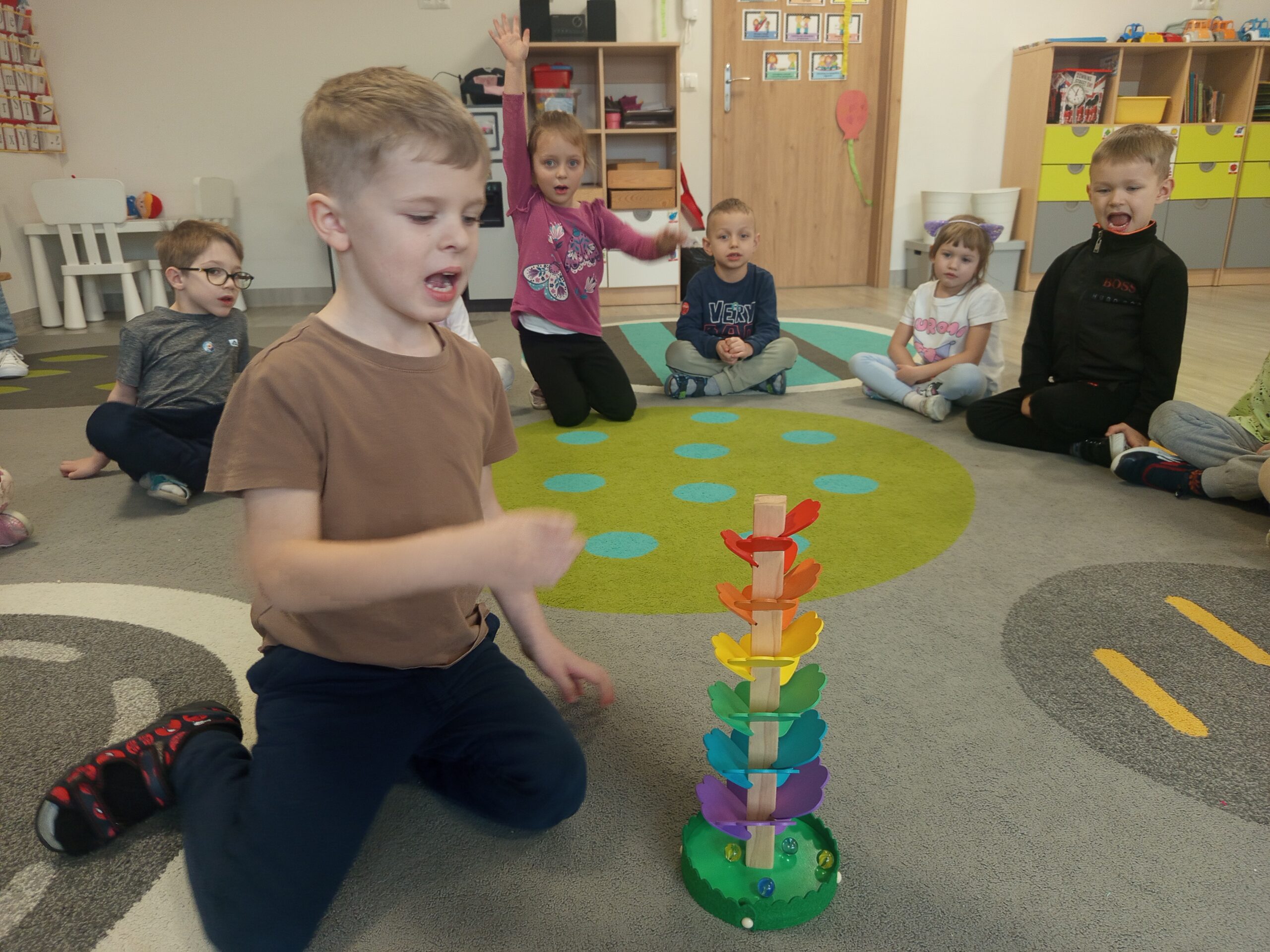 Dzieci ćwiczą, bawiąc się kulodromem.