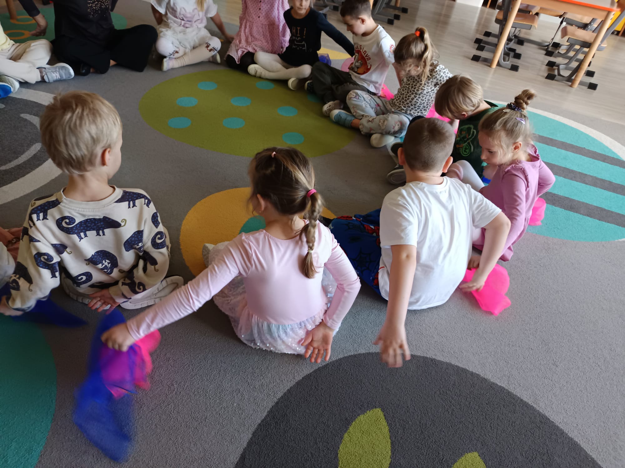 Dzieci podają sobie chustkę z zamkniętymi oczami.