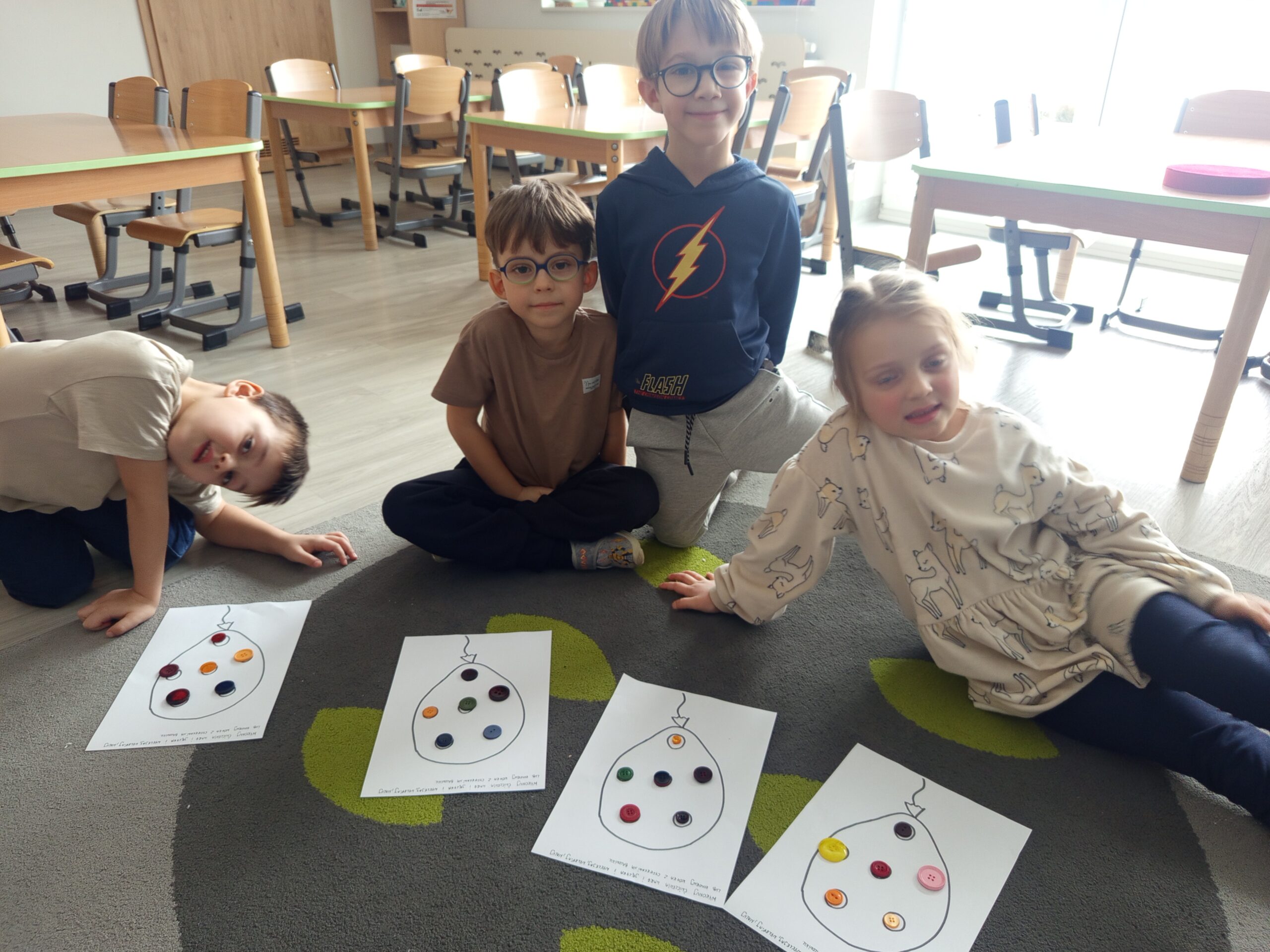 Dzieci uzupełniają baloniki guzikami.