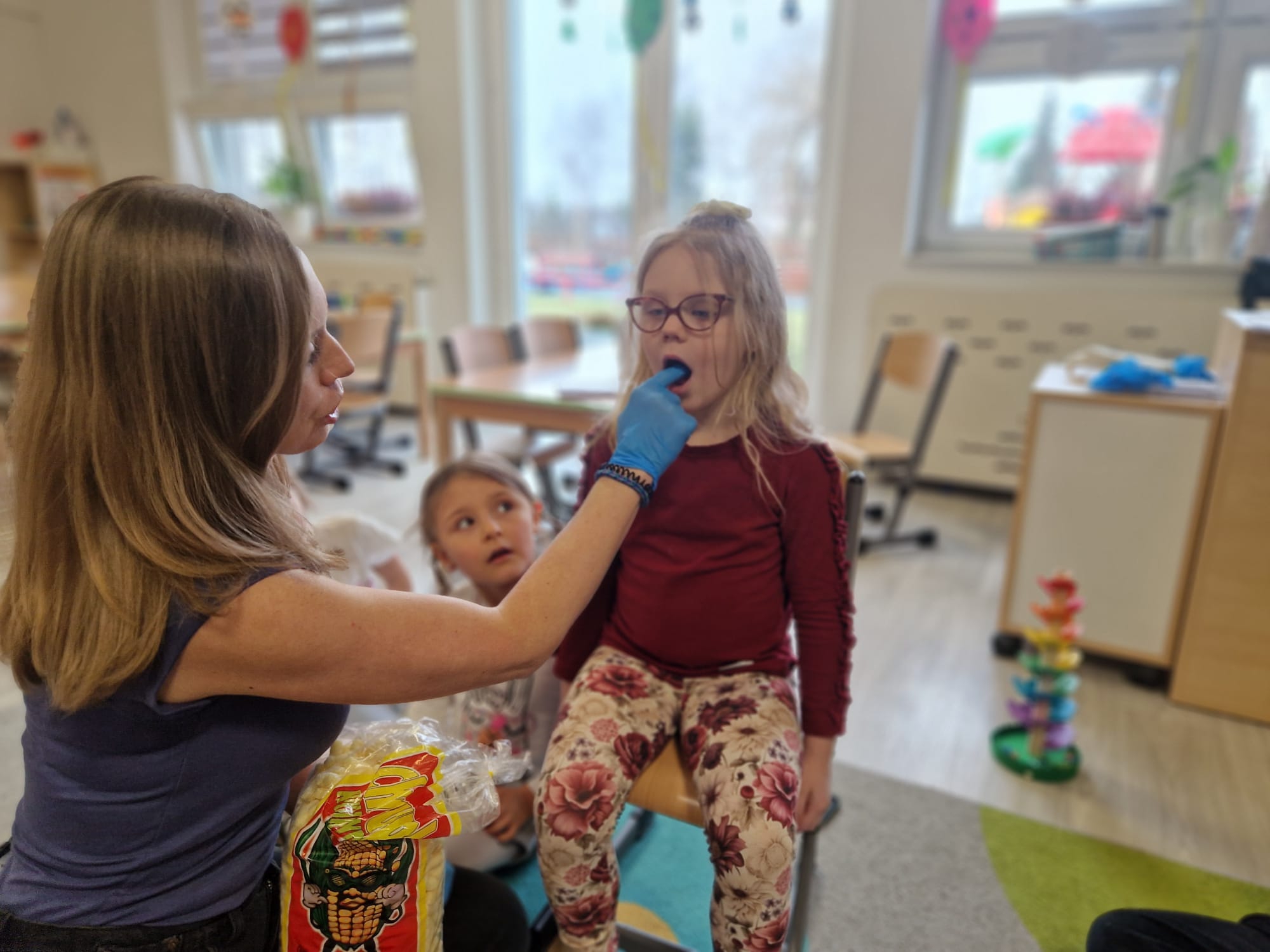 Dziewczynka prezentuje ćwiczenie z chrupkiem.